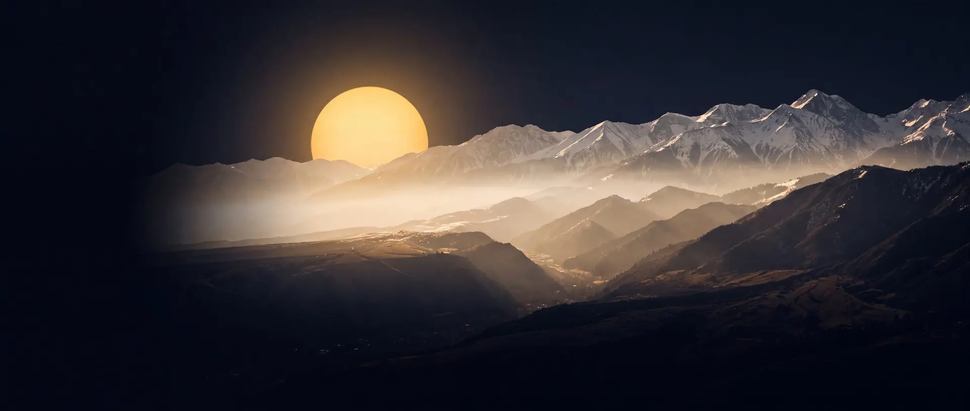 Snow-capped Zailiysky Alatau mountains above Almaty at golden dusk